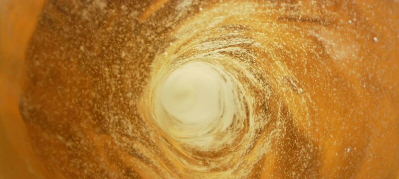 Beer with bubbles moves in a glass in slow-motion. Abstract water background. Seamless loop 3d render