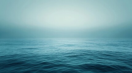 Fototapeta premium A serene ocean with mist on the horizon and calm waters