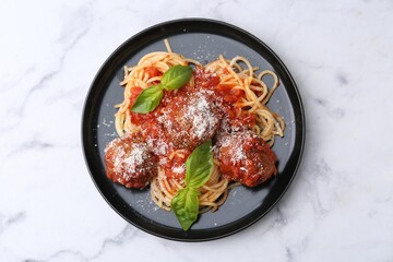 Delicious pasta with meatballs, basil and cheese on white marble table, top view