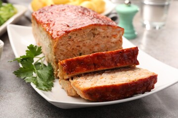 Delicious baked turkey meatloaf with parsley on grey table, closeup