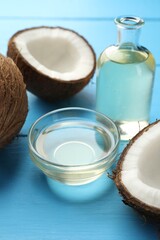 Organic coconut cooking oil and fresh fruits on light blue wooden table, closeup