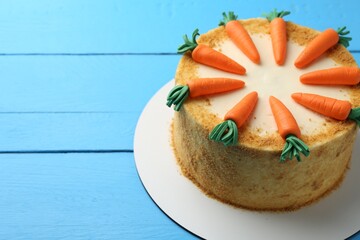 Delicious homemade carrot cake on light blue wooden table, space for text