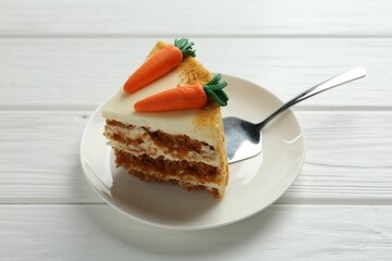 Piece of delicious homemade carrot cake and server on white wooden table