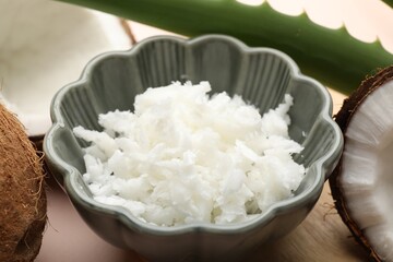 Hair treatment. Coconut, butter shavings and aloe leaves on beige background, closeup