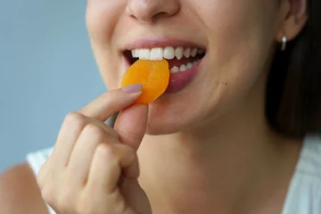 Fotobehang Apricot dried. Close-up of unidentified girl eating apricot fruit dried. Healthy food concept. © zigres