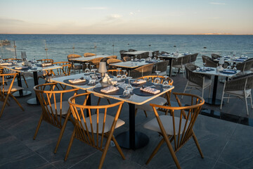 A romantic seaside restaurant with perfectly arranged tables, glassware