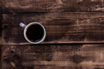 A cup of black coffee in wood