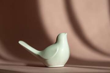 abstract image: white bird figurine on a soft pink background. symbol of spring and tenderness