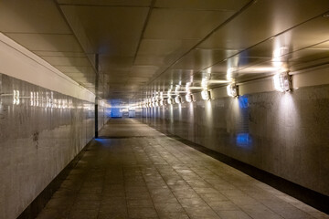 Empty underground tunnel illuminated by soft lighting in urban area at night