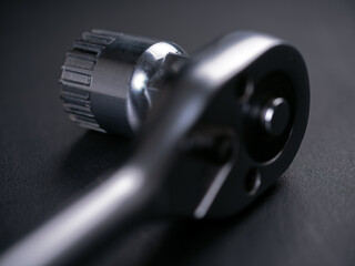 Special bicycle wrench for mounting and dismounting the bicycle bottom bracket on a dark background.