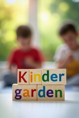 Fototapeta premium Wooden blocks spelling kindergarten with children playing in background