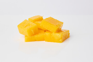 Fresh mango cubes resting on a white background
