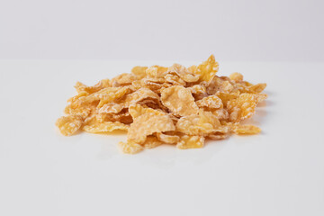 Crunchy corn flakes piled on a white background creating a delicious breakfast treat