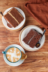Delicious cappuccino, chocolate cakes and heart shaped cookie lying on wooden table