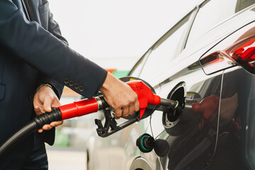 Close-up of man's hand filling up car at gas station with equipment ZVA