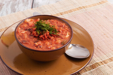 Bowl of delicious chorizo and bean soup garnished with fresh parsley