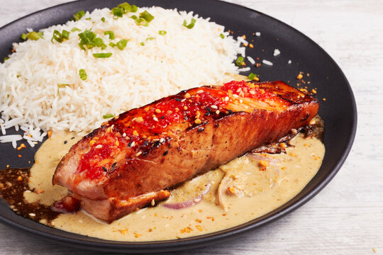 Delicious pan seared salmon with rice and spicy creamy sauce