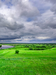Naklejka premium Cloudy sky with a green field in the background