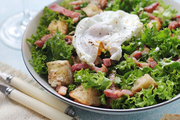 A bowl with salad lyonnaise served for lunch	