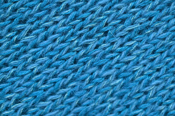 blue texture of knitted wool fabric as a background, smooth symmetrical lines of hand-knitted needlework pattern	
