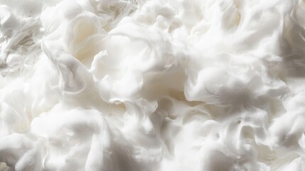 Fototapeta premium Close-up of white foamy texture with soft swirls and curves