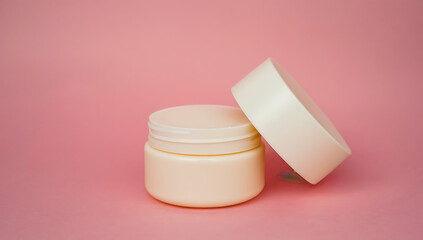 Cosmetic cream jar on pink background