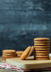 stack of delicious almond biscuits on a wooden board isolated dark background
