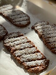 Swedish Chocolate Cookies, Cut into Long Strips, Topped with Swedish Pearl Sugar, on a Baking Tray in Warm Sunlight.