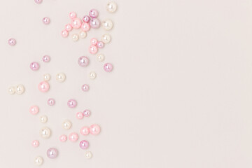 Multicolored imitation pearl beads scattered on a gray background. Needlecraft concept with place for your design.