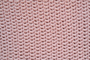 pink crocheted fabric as a background, handmade, close-up of a fragment of a blanket 
