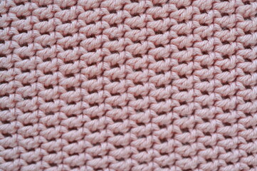 pink crocheted fabric as a background, handmade, close-up of a fragment of a blanket 
