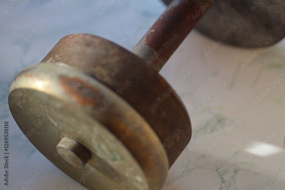 Poster Close-up of a metal object on a table with minimal background distraction.