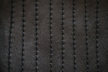 black leather texture close-up, seams on leather jacket as background, black natural leather as background, black leather stitching