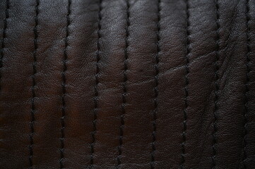 black leather texture close-up, seams on leather jacket as background, black natural leather as background, black leather stitching
