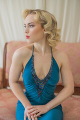 Beautiful blonde pinup girl, glamorous woman, American model in classy green dress