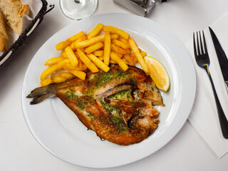 Appetizing grilled gilthead sea bream fish served with potatoes on platter