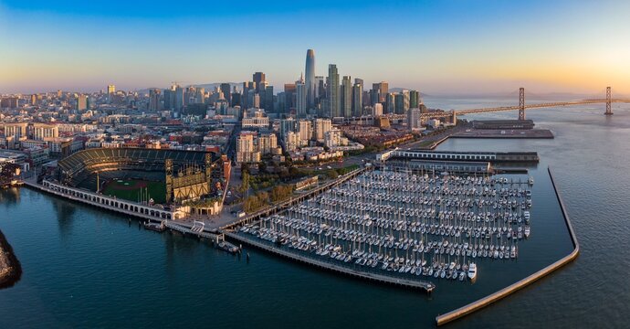 San Francisco skyline, Oracle Park, and a bustling marina at sunrise. Aerial view of the city's iconic landmarks. South Beach Harbor, San Francisco, California, USA