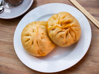 National Asian dish of baozi pan chino is dumplings stuffed with minced meat. Dish is served with spicy soy sauce, chopsticks, and cutlery.