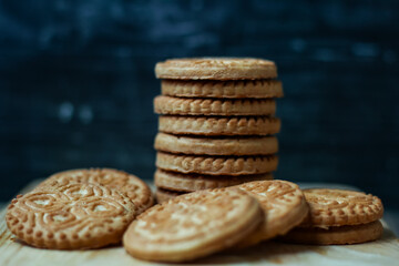 stack of delicious almond biscuits on a wooden board isolated dark background