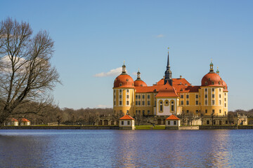 Fototapeta premium Stunning views Moritzburg Castle with Baroque architecture reflected in calm waters nearby lake.Perfect for capturing grandeur and elegance of European castles. Germany