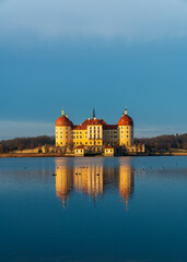 Fototapeta premium Stunning views Moritzburg Castle with Baroque architecture reflected in calm waters nearby lake.Perfect for capturing grandeur and elegance of European castles. Germany