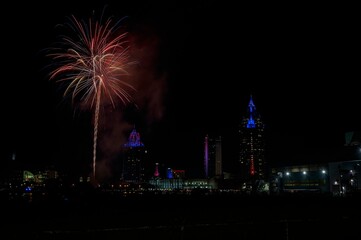 Red and gold fireworks bursting over a city skyline at night