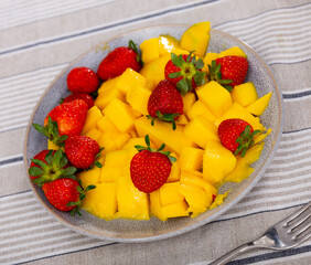 Sweet juicy mango slices served with delicious strawberries