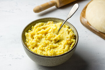 Mashed potatoes with fried onions and dough for kreplach or dumplings preparation on a gray background