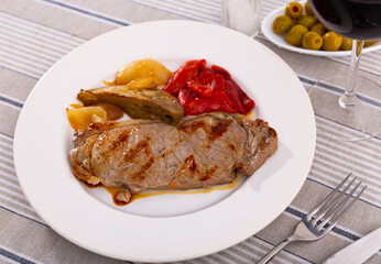 Nicely served plate of tasty beef steak with baked tomatoes and onions