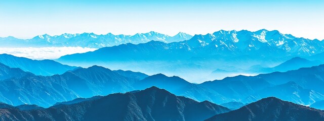 Aerial panoramic view of tropical mountains covered in lush greenery with mist and fog in the distance, under a vast blue sky with scattered white clouds, creating a serene and breathtaking landscape.