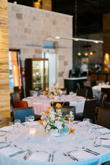 Round festive table with a bouquet of flowers stands in a restaurant
