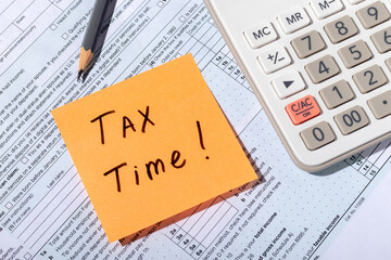Inscription Tax Time on sticker on individual income tax return form 1040 close-up