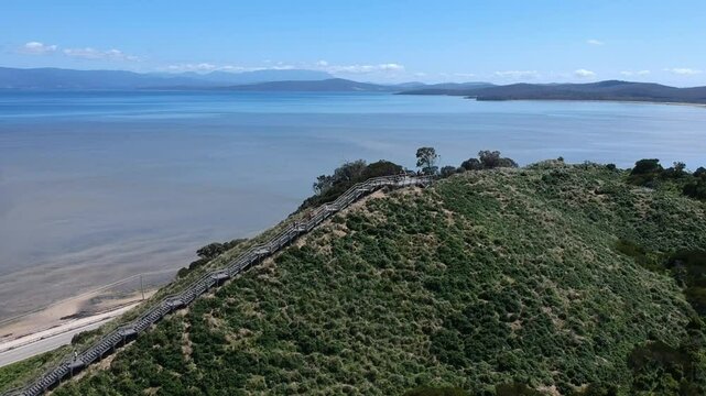 Breathtaking aerial drone footage of Neck Lookout on Bruny Island, Tasmania, showcasing panoramic coastal views, pristine beaches, turquoise waters, and the famous narrow isthmus.