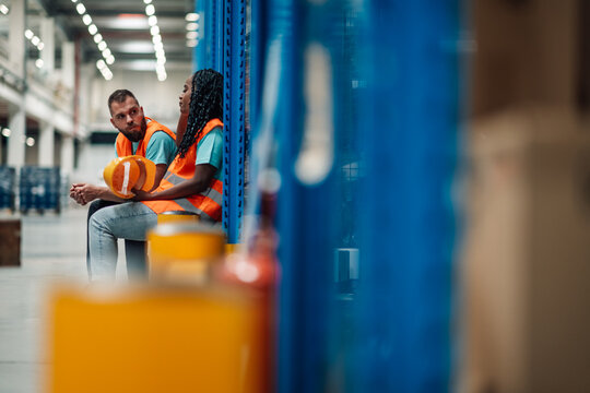 Warehouse workers taking a break and chatting in distribution center